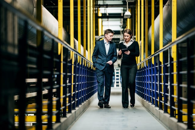 two people walking through a manufacturing plant 